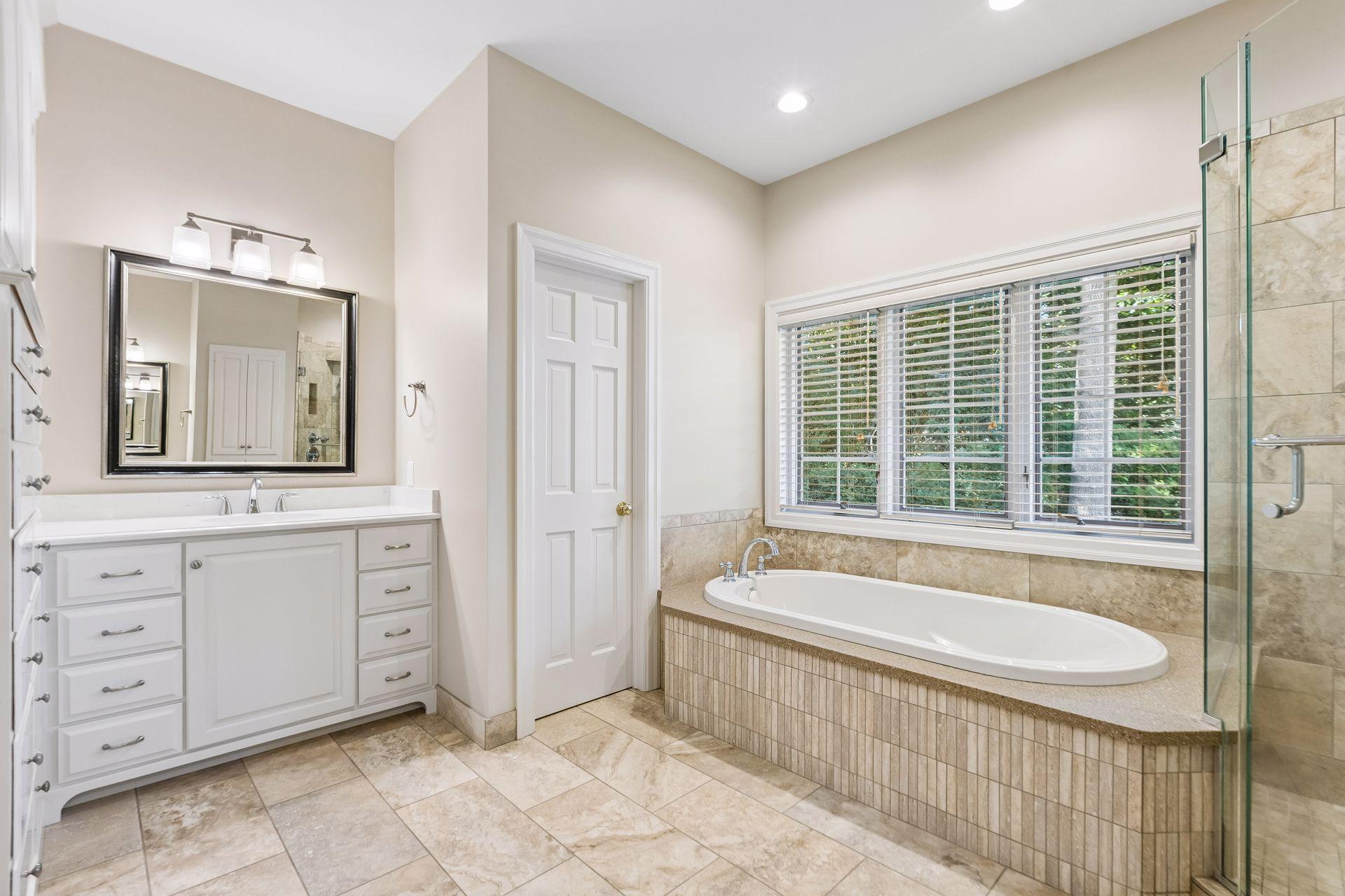 Primary bathroom features two large vanities along with a relaxing soaking tub.