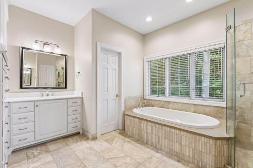 Primary bathroom features two large vanities along with a relaxing soaking tub.