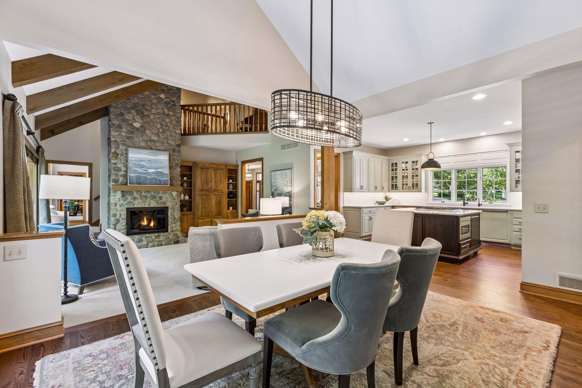 Cozy vaulted family room sits beside the informal dining area and features a stunning stone wood-burning fireplace.