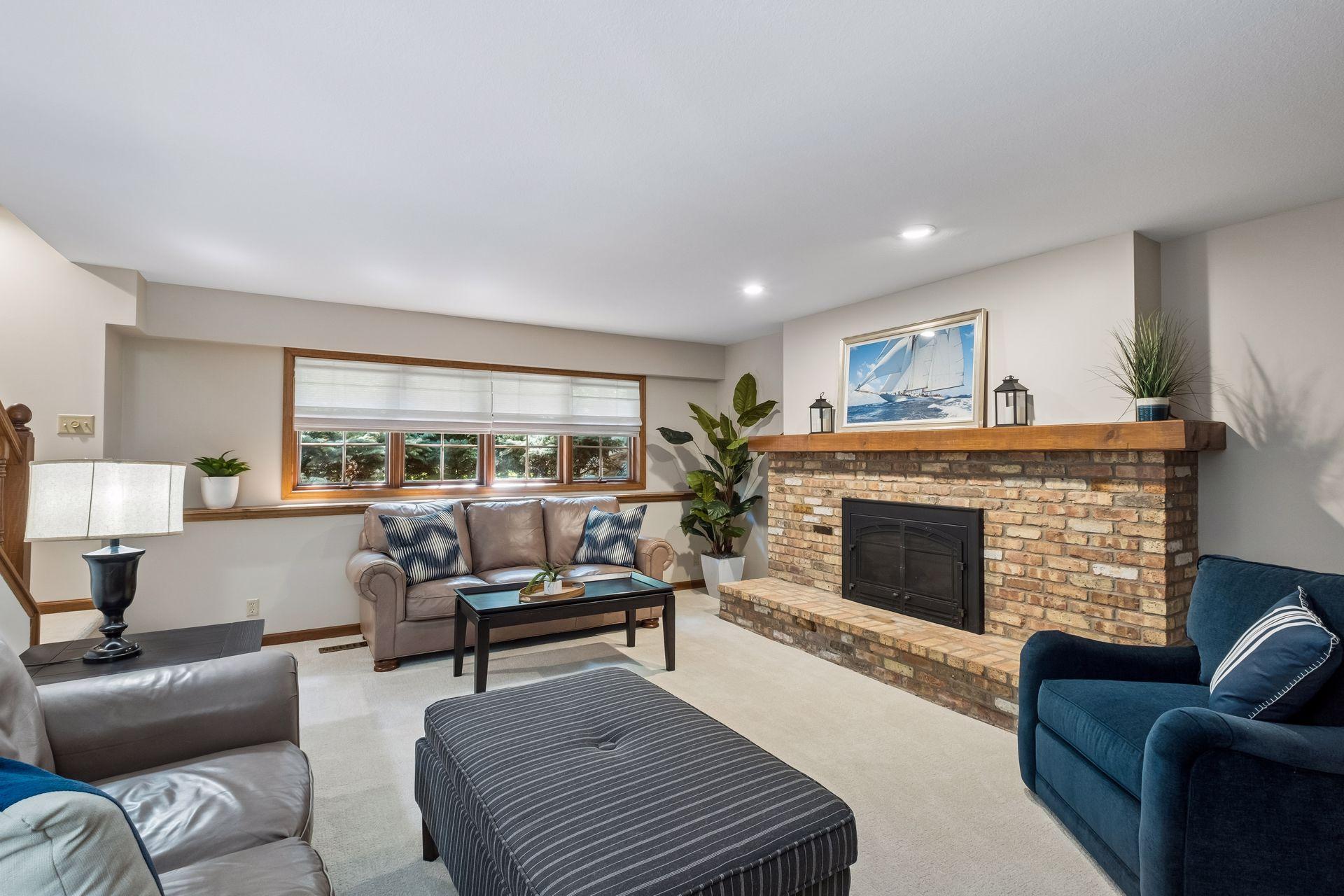 Spacious lower-level family room with a fireplace and natural light from backyard-facing windows.