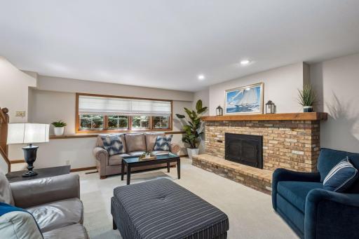 Spacious lower-level family room with a fireplace and natural light from backyard-facing windows.