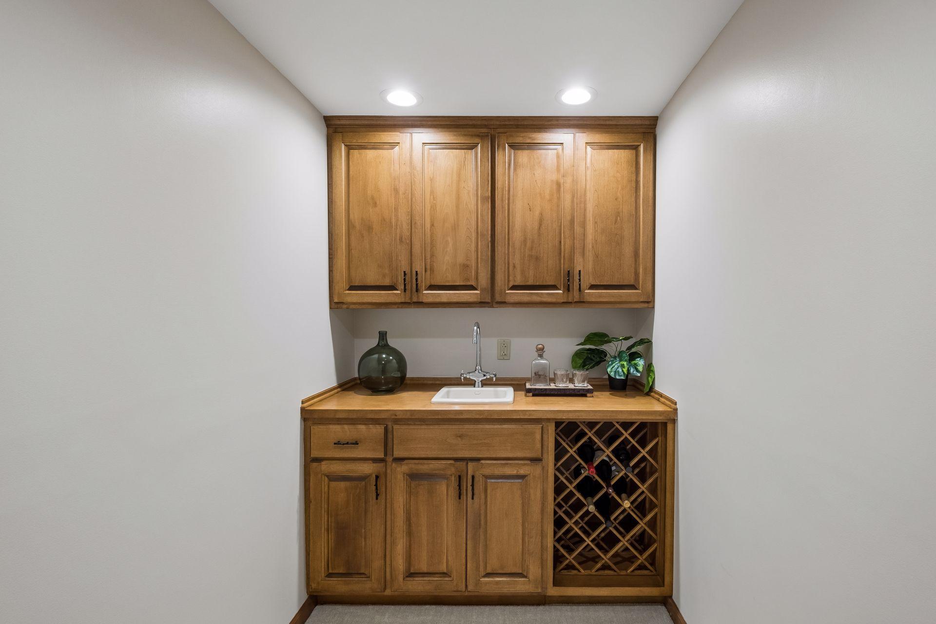 Stylish wet bar featuring a wine rack and custom built-ins adjacent to the lower-level family room.
