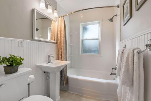 The main floor bath has charming wainscoting and deep storage cabinets (not shown)