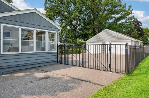 The back yard is fully fenced and includes a double-door gate across the driveway