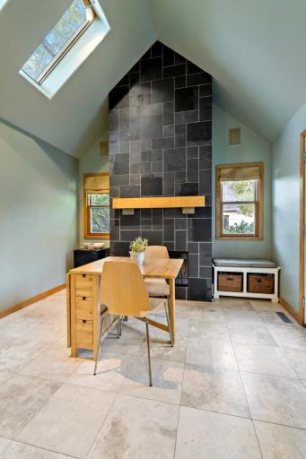 The dining area's two-story slate fireplace is the heart of the home - flanked by windows, flooded with light, and opening directly to the back deck.