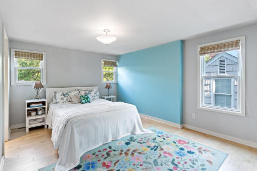 The upstairs primary suite offers new maple hardwood floors (2023), multiple windows, a walk-in closet, and room for a sitting area or home office.