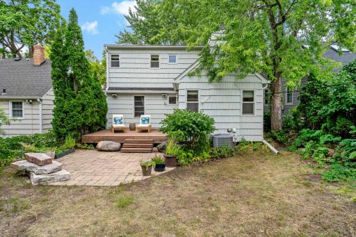 The backyard has a wood deck, paver patio, and mature landscaping with enough room for play, entertaining, and relaxation.