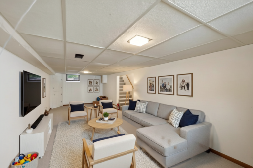 Endless possibilities in the finished lower level — gym, lounge, and workspace all in one. Make it your own! (AI-Staged)