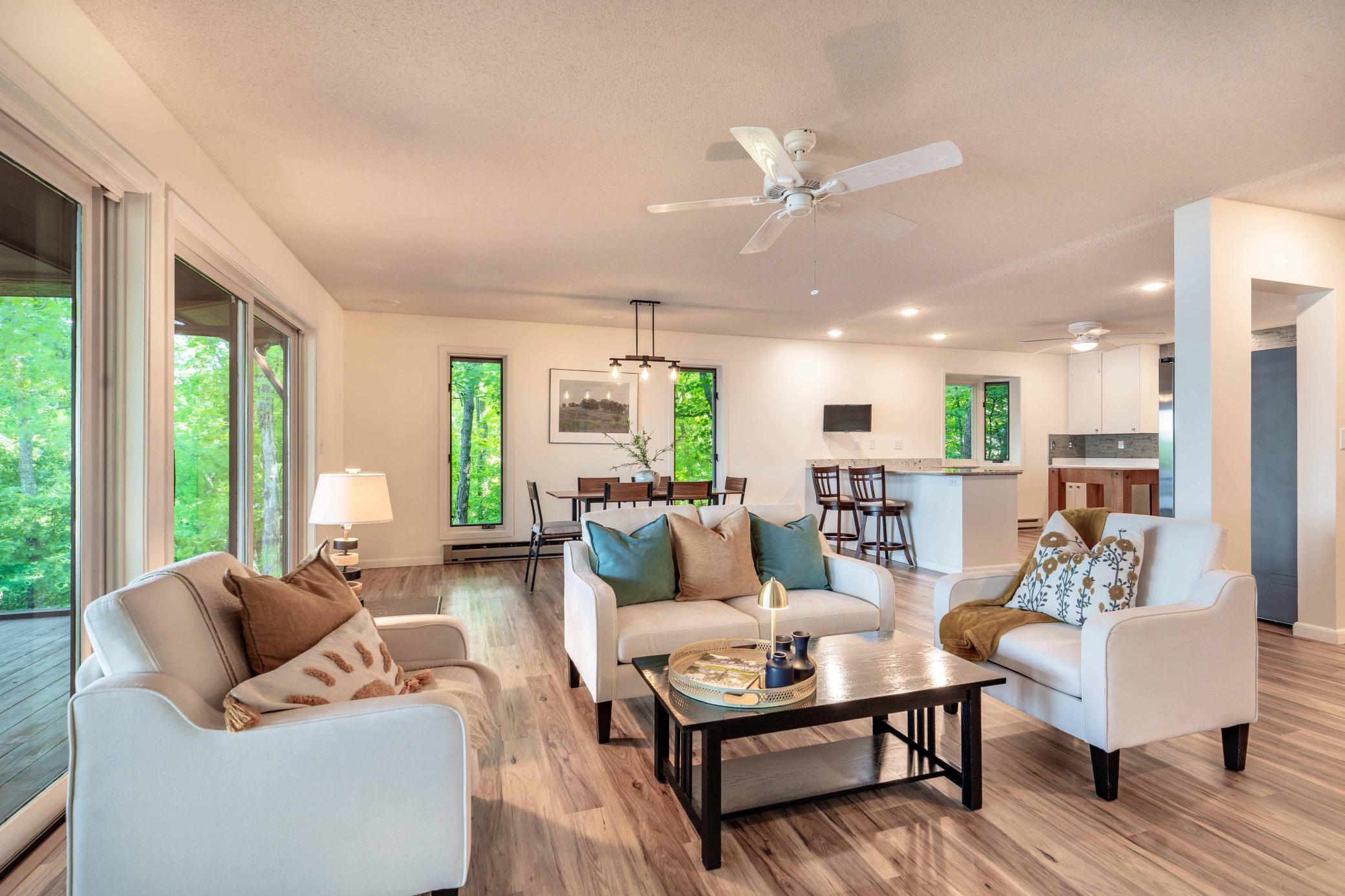 Unique windows flank the dining set with wooded and lake views surrounding the home.
