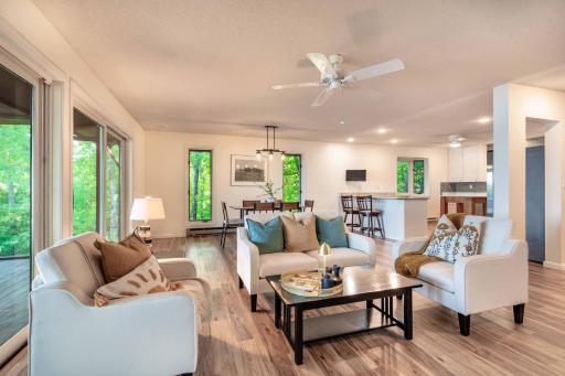 Unique windows flank the dining set with wooded and lake views surrounding the home.