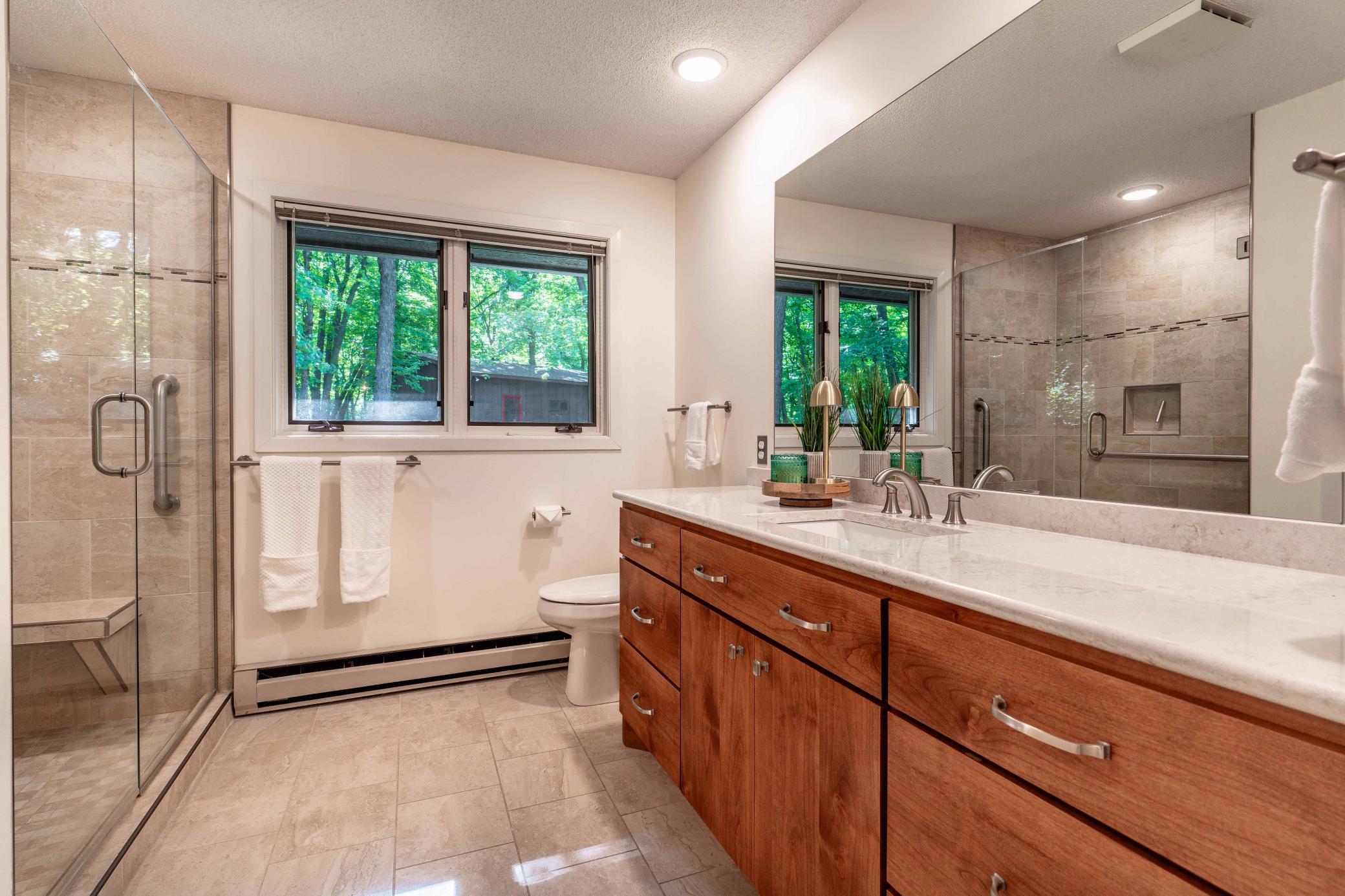 3/4 Bath with gorgeous custom vanity and tile floor and shower