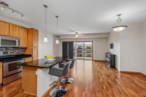 The generous center island provides additional prep space and casual seating, while hardwood floors continue into the adjoining living areas, creating a cohesive feel throughout the main living space.