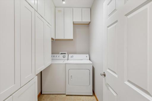 Convenient in-unit laundry with generous built-in cabinetry for household storage