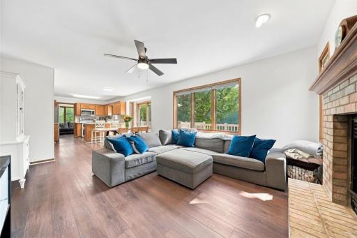 Spacious living room with gas fireplace and large picture window framing the beautiful backyard.