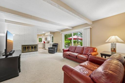 Main floor family room with 2 sided wood burning fireplace. Sliding door to the peaceful backyard patio