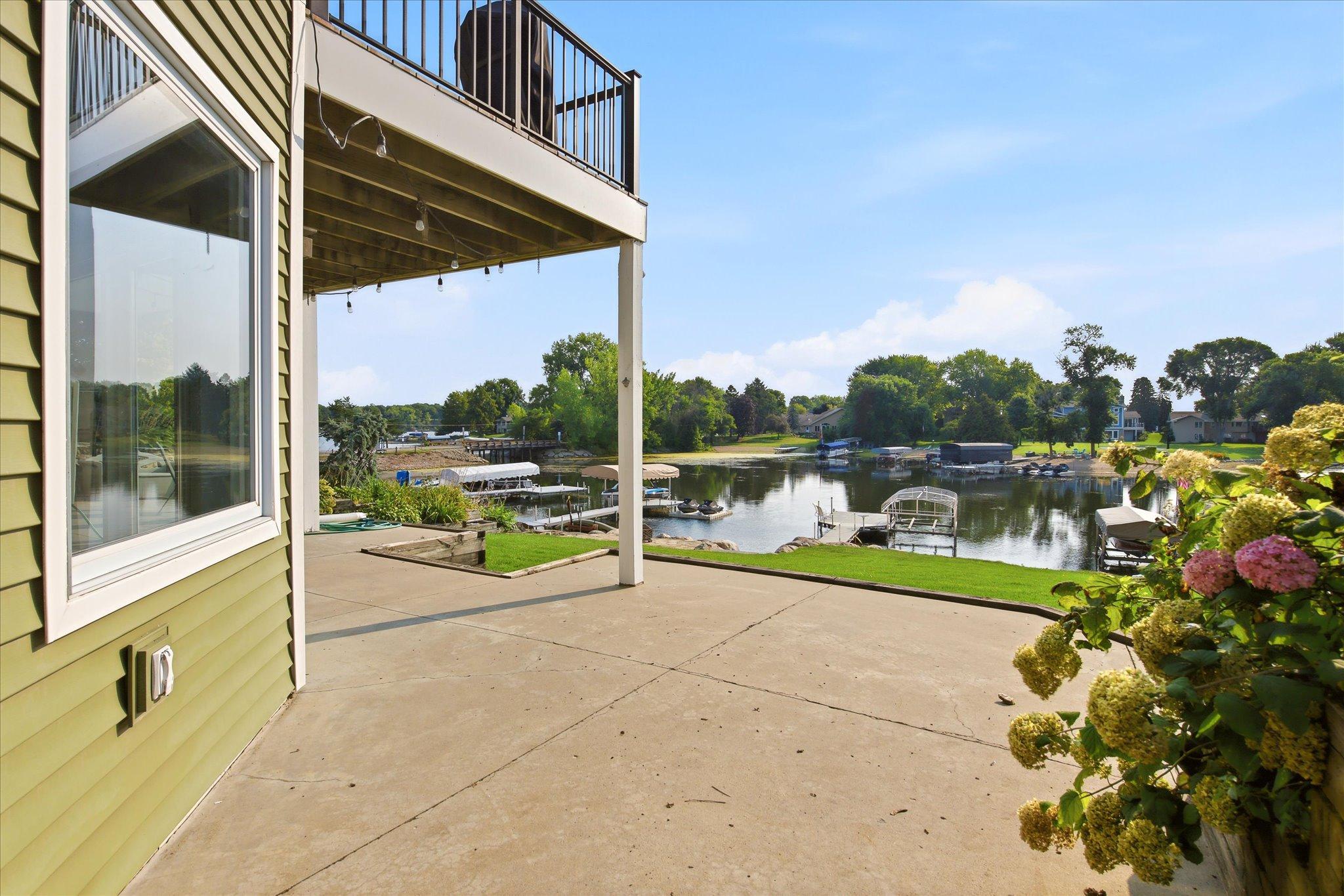Lakeside patio and outdoor living area with views toward the shoreline and dock.