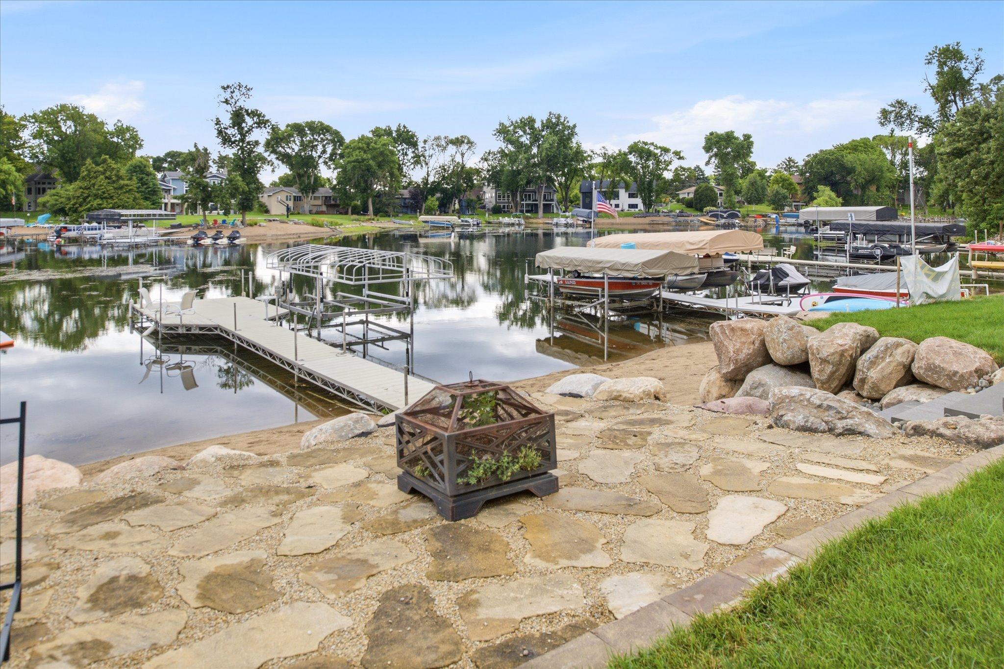 Lakeside stone patio adjacent to the recently installed boulder shoreline retaining wall.