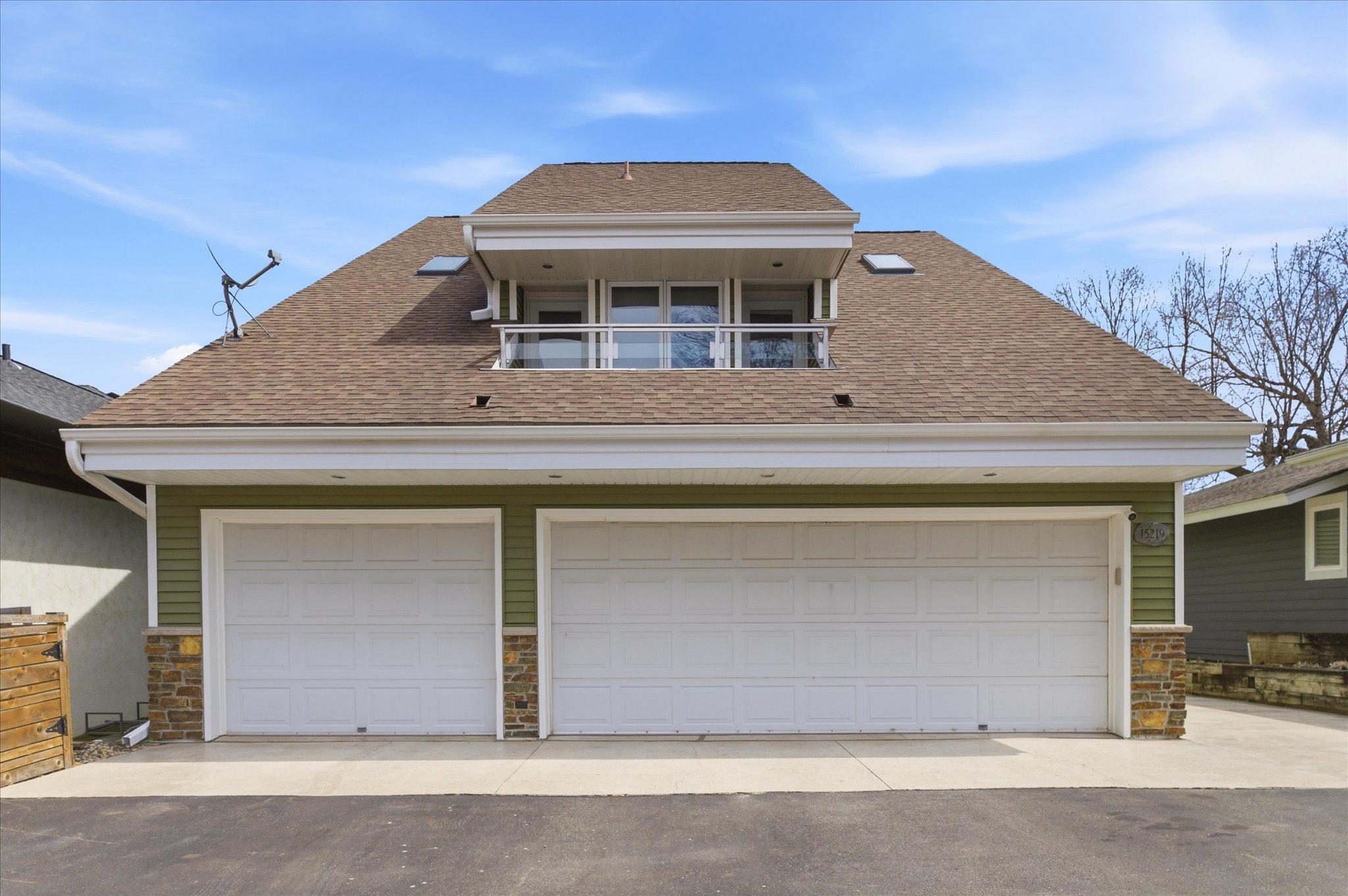Front elevation featuring a three-car heated garage, updated entry, and maintenance-free exterior.