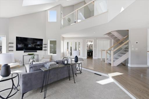 Great room with vaulted ceilings, skylights, open staircase, and abundant natural light.
