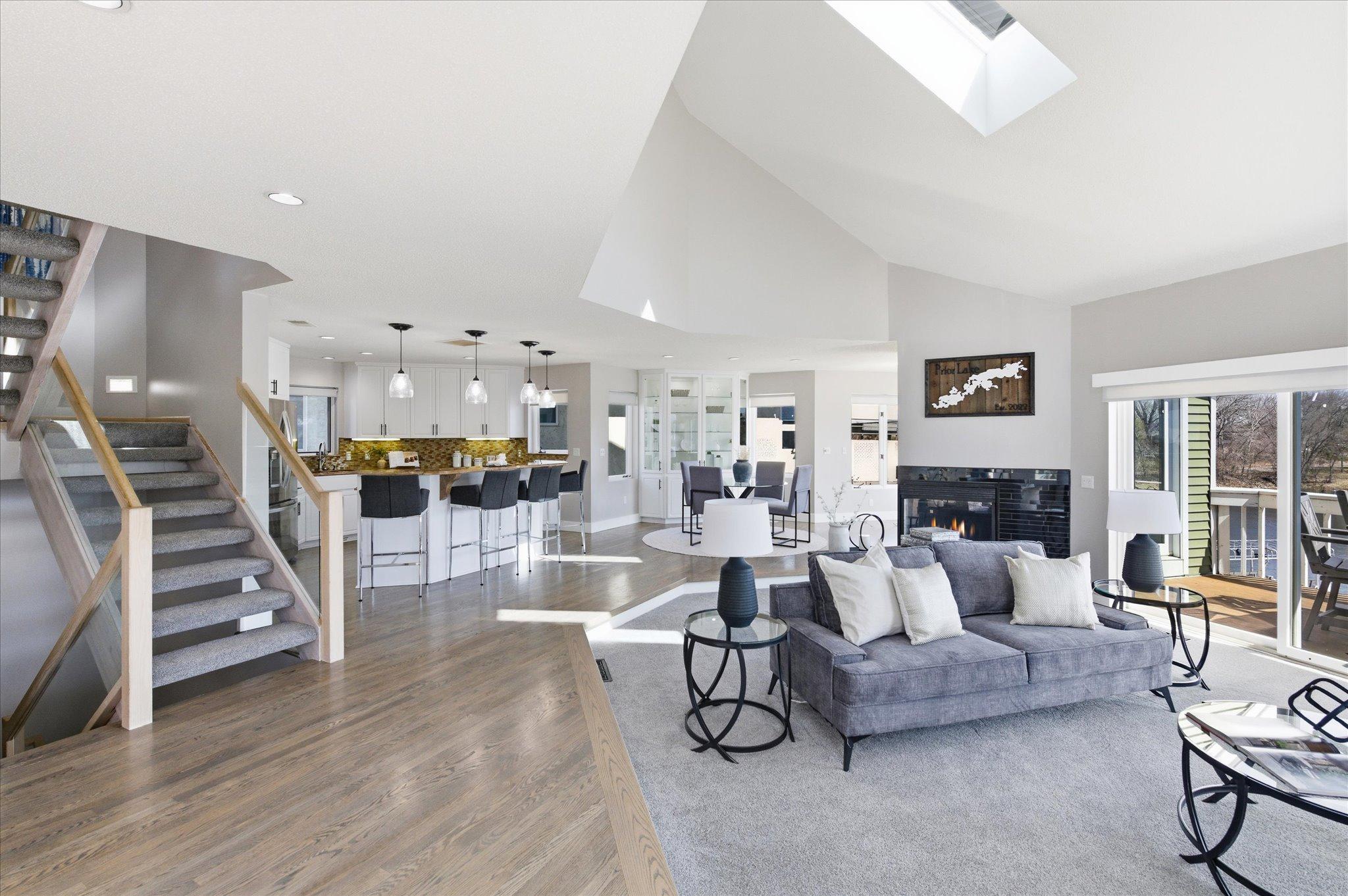 Open-concept main level with vaulted ceilings, skylights, gas fireplace, and seamless flow to the kitchen and dining area.