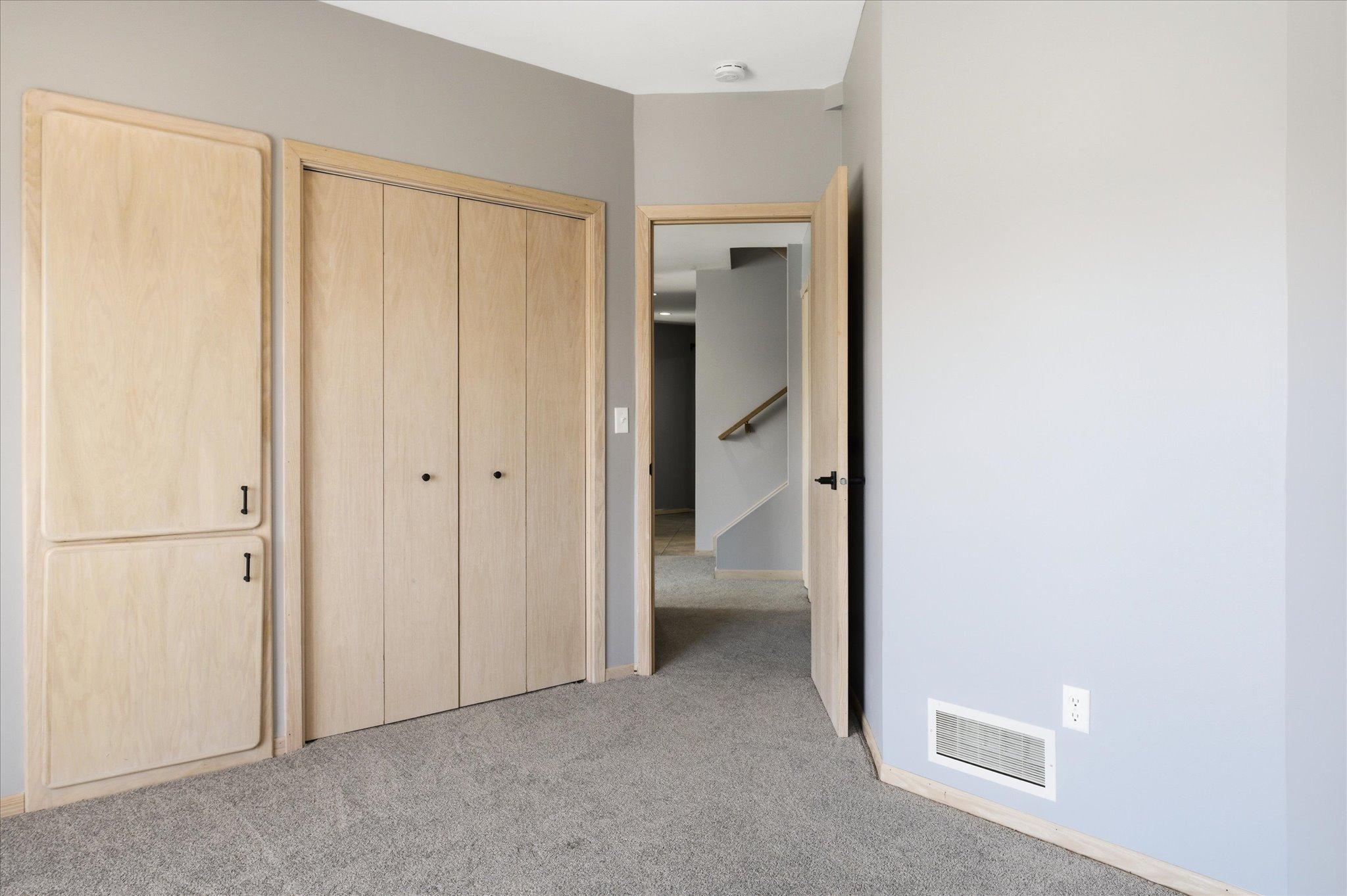 Alternate view of the walkout bedroom with closet and adjacent hallway access.