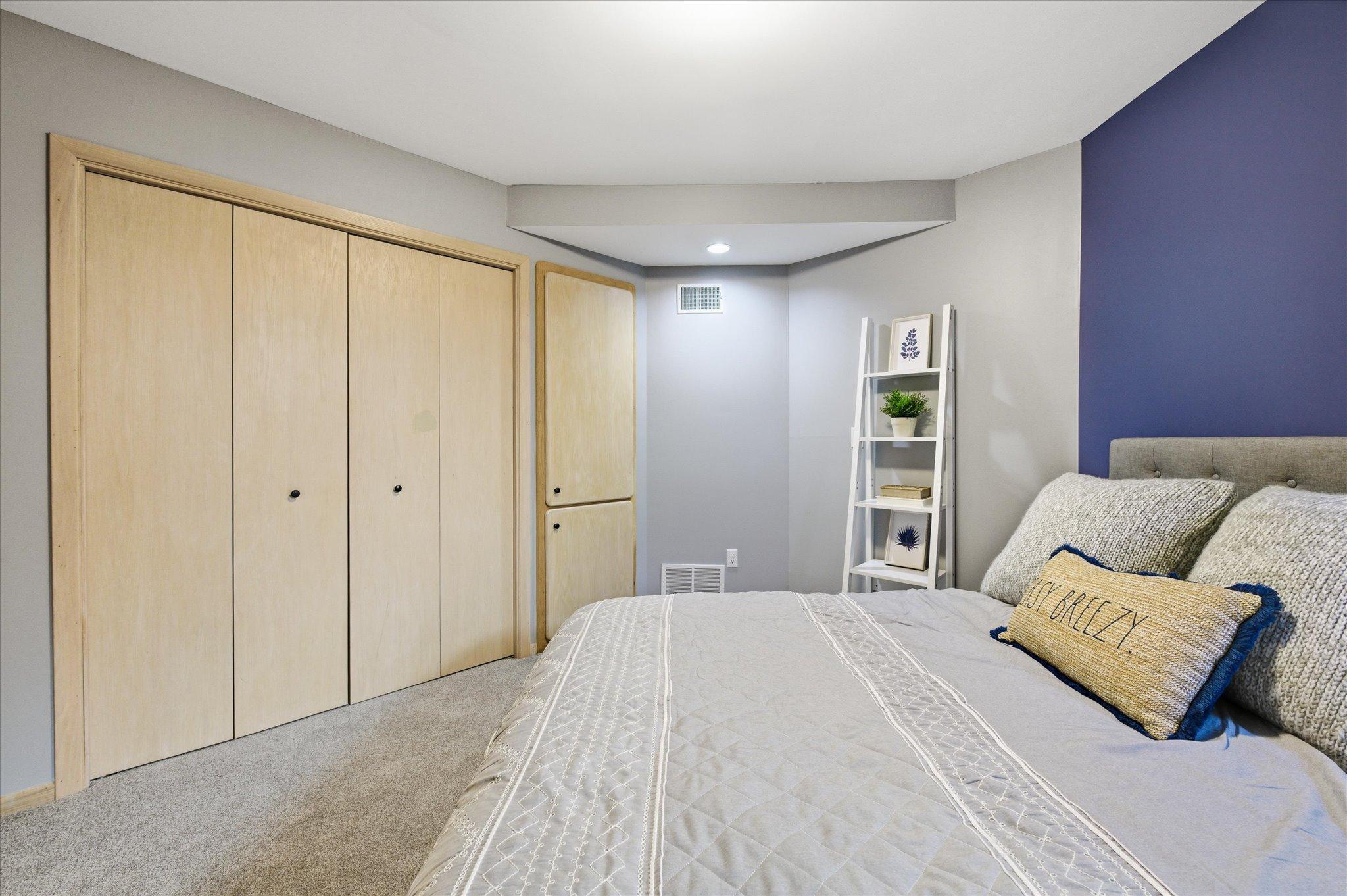 Alternate view of the lower-level bedroom featuring built-in storage and closet.