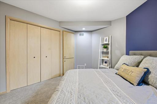 Alternate view of the lower-level bedroom featuring built-in storage and closet.