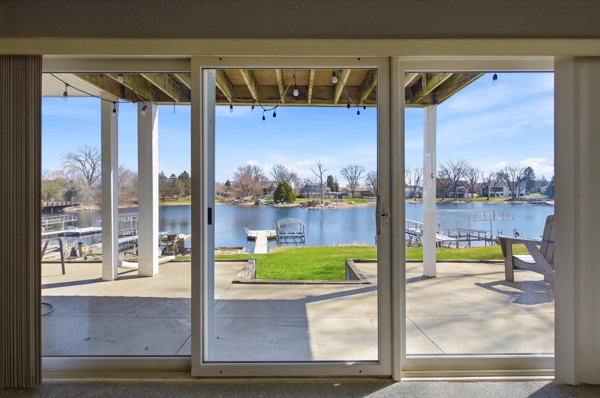 Walkout patio access overlooking the level backyard, private dock, and lake.
