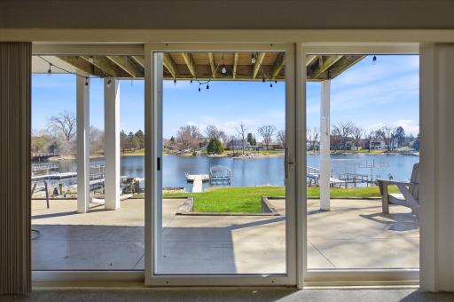 Walkout patio access overlooking the level backyard, private dock, and lake.