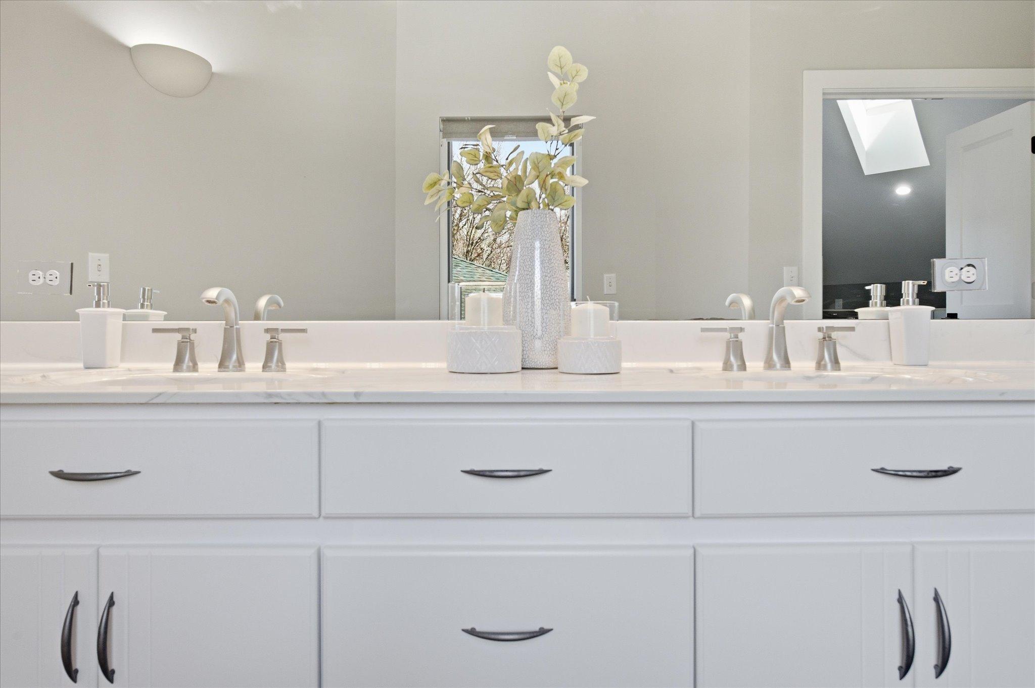 Primary bathroom featuring a dual-sink vanity and updated finishes.