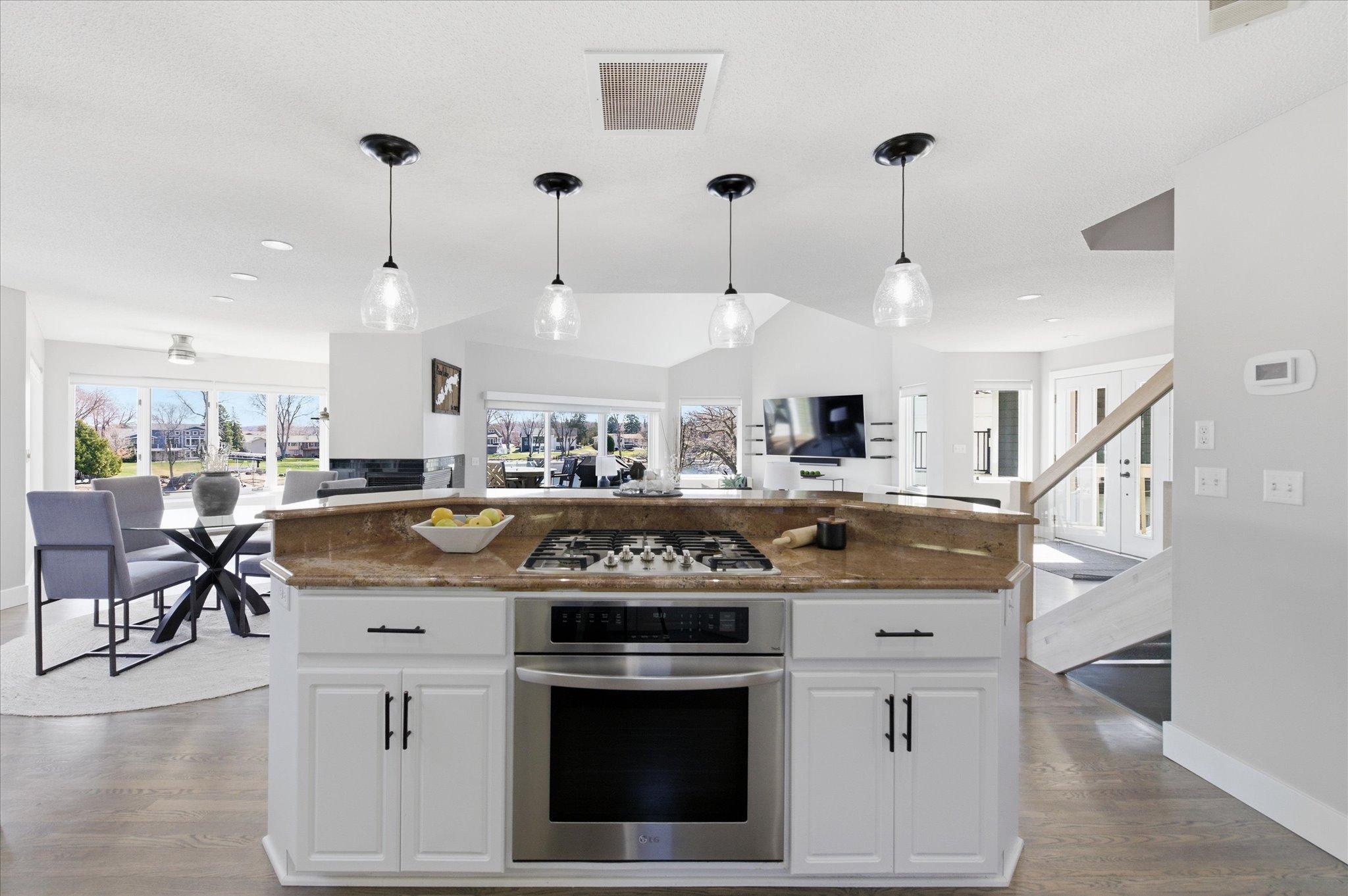 Center island with gas cooktop overlooking the dining and living areas.
