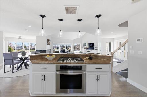 Center island with gas cooktop overlooking the dining and living areas.