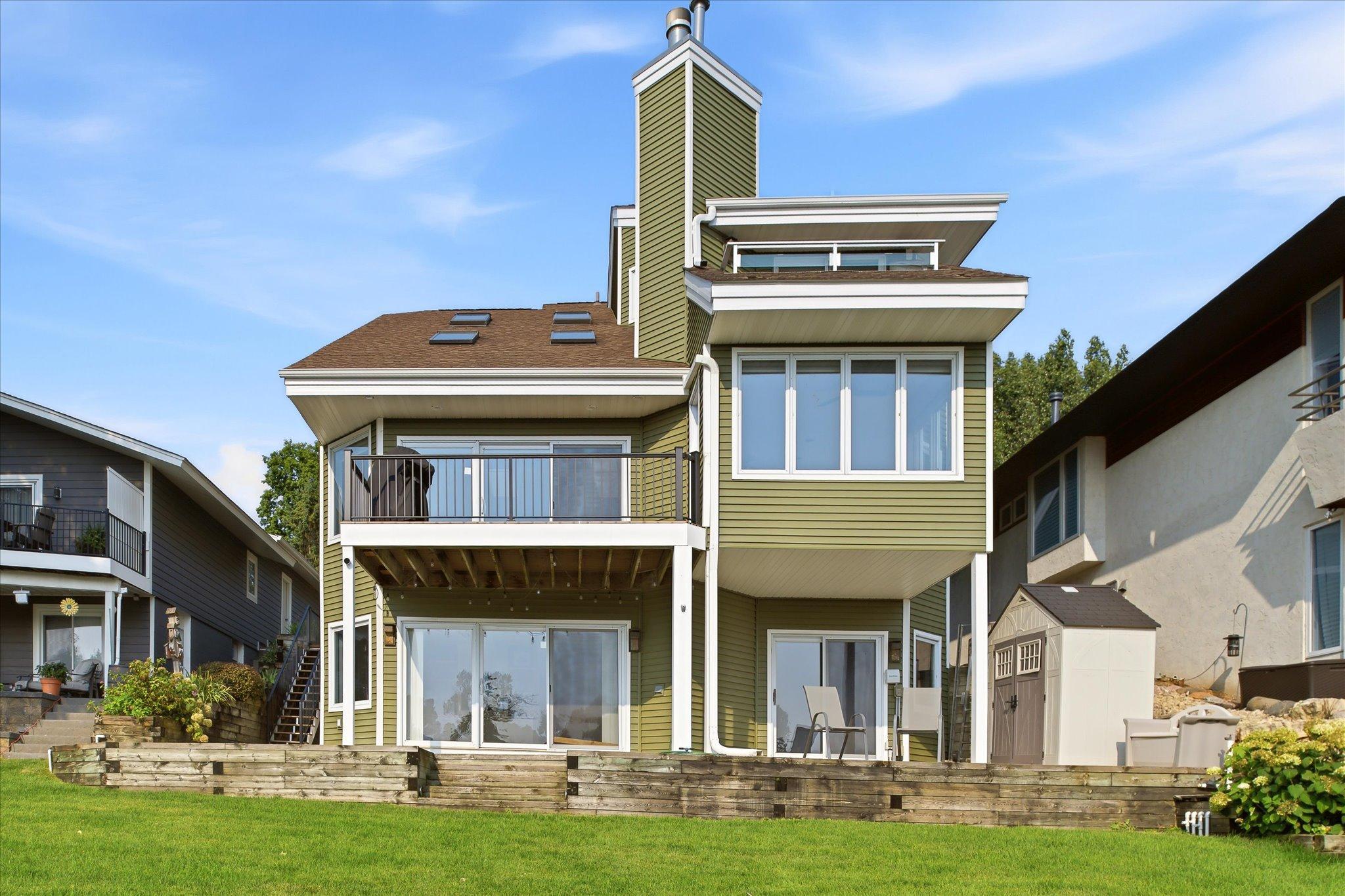 Rear exterior highlighting the home’s multi-level design and newly installed deck railings.