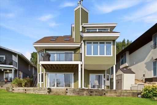 Rear exterior highlighting the homeâs multi-level design and newly installed deck railings.