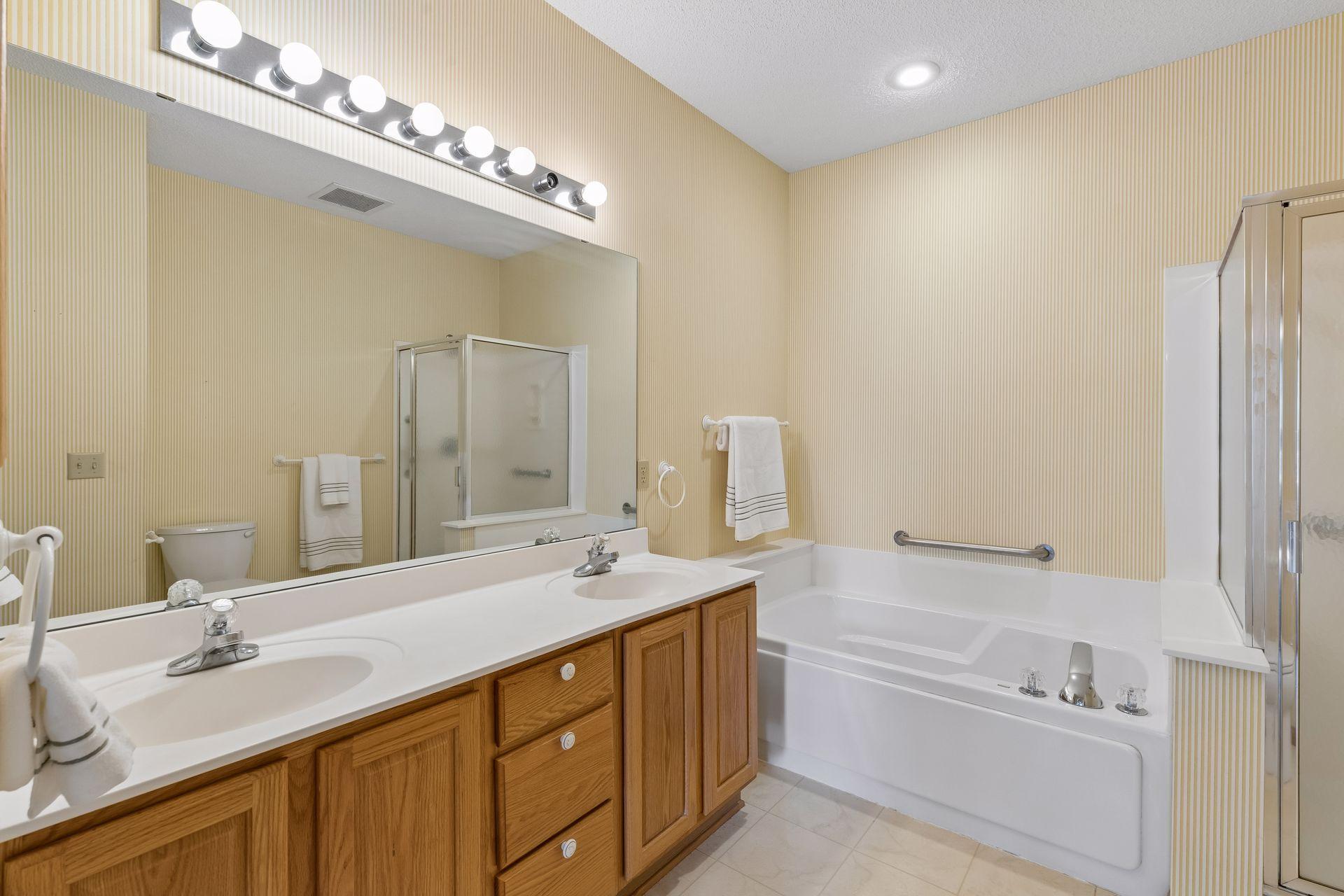 The primary bathroom with dual sinks, separate tub and shower and plenty of lighting!