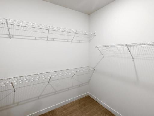Spacious primary walk-in closet provides excellent shelving and hanging space. Photo shown is from a previously built home; selections and finishes may vary.