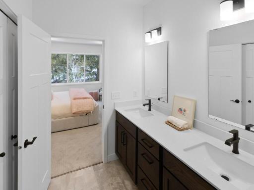 Dual vanities provide plenty of personal space and storage in the private primary bath. Photo shown is from a previously built home; selections and finishes may vary.