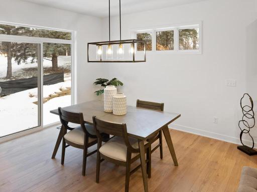 Open kitchen and dining area create a welcoming space for gathering and entertaining. Photo shown is from a previously built home; selections and finishes may vary.