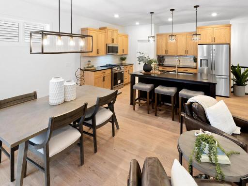 Open kitchen and dining area create a welcoming space for gathering and entertaining. Photo shown is from a previously built home; selections and finishes may vary.