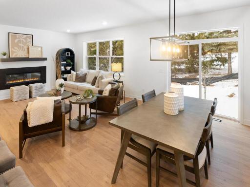 Great room flows effortlessly into the dining area with access to the outdoor living space. Photo shown is from a previously built home; selections and finishes may vary.