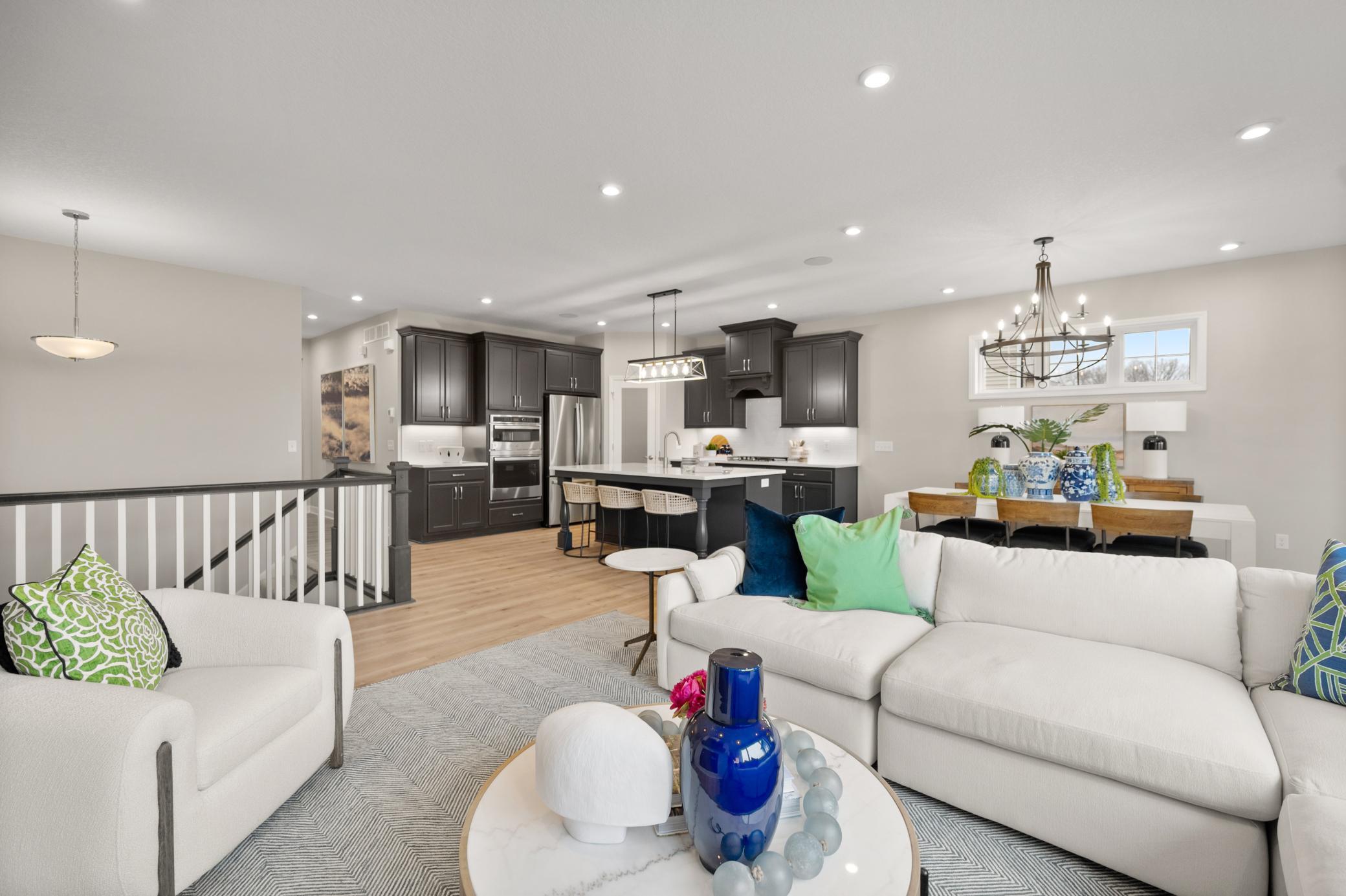 Guest perspective of the family room as it seamlessly flows to the kitchen and dining areas. (model photo)