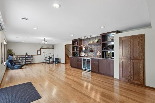 Basement Rec Room: Large finished recreation and entertainment room featuring a built-in bar with custom cabinetry, offering plenty of space to gather, relax, and entertain.
