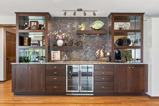 Basement Rec Room: Large finished recreation and entertainment room featuring a built-in bar with custom cabinetry, offering plenty of space to gather, relax, and entertain.