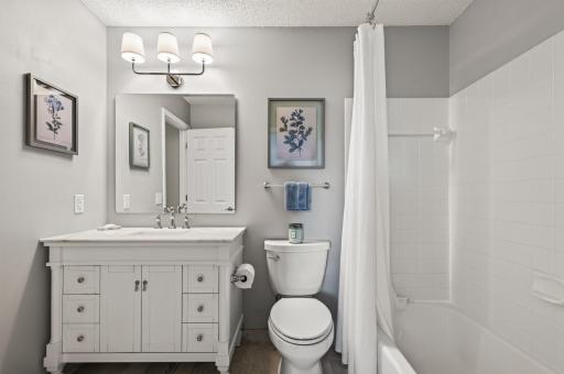 Updated walk-thru bath with marble tile floor.