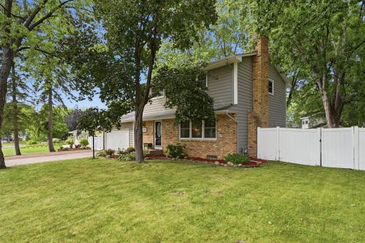 Classic two-story character framed by mature trees in an established New Hope neighborhood.