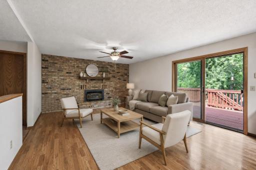 Virtually staged main level family room with wood burning fireplace.