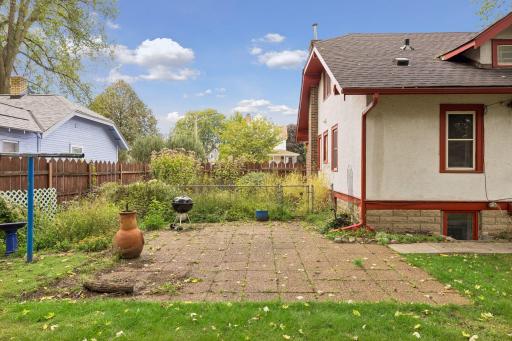 Behind the patio is a large fenced-in garden area.