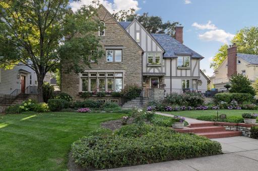 2116 West Lake of the Isles Parkway -Mature landscaping beautifully frames the home's Tudor architecture and original stonework. Exceptional curb appeal, with lush gardens and timeless stone detailing creating a remarkable sense of arrival.