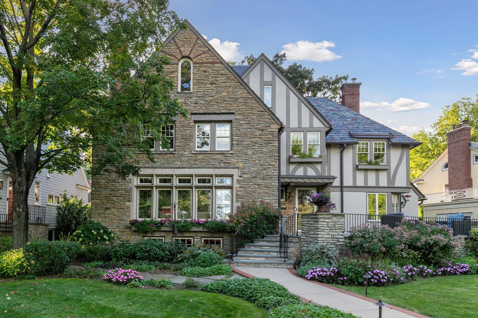 Beautifully maintained gardens soften the home's substantial stone façade and create color throughout the summer months.