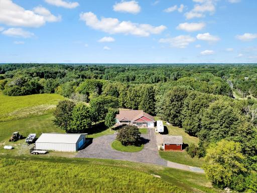 Home with attached garage, pole barn, storage shed and circle drive.